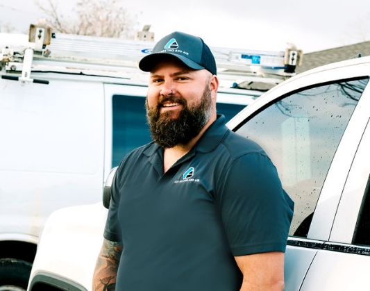 H V A C contractor Joe smiling and standing against white pickup truck