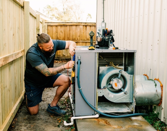 Contractor adjusting an outdoor H V A C system