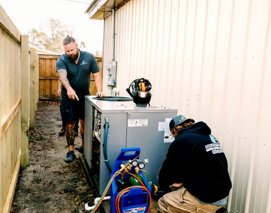 Two contractors adjusting an outdoor H V A C system