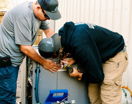 Two contractors installing new H V A C units in Panama City