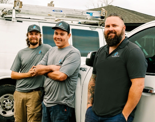 Three Panama City H V A C contractors smiling and standing against white pickup truck