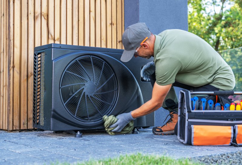 an HVAC professional cleaning an AC unit