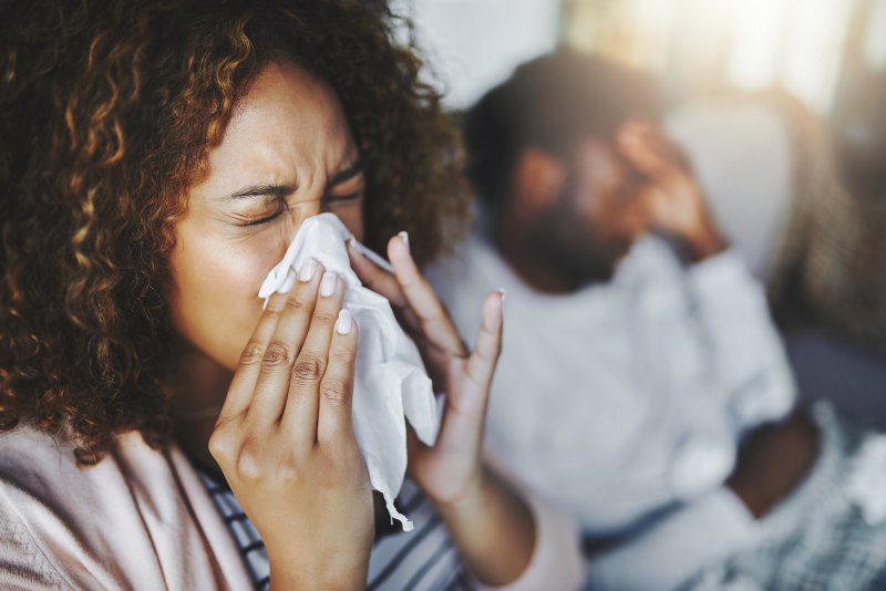 a woman blowing her knows due to allergies