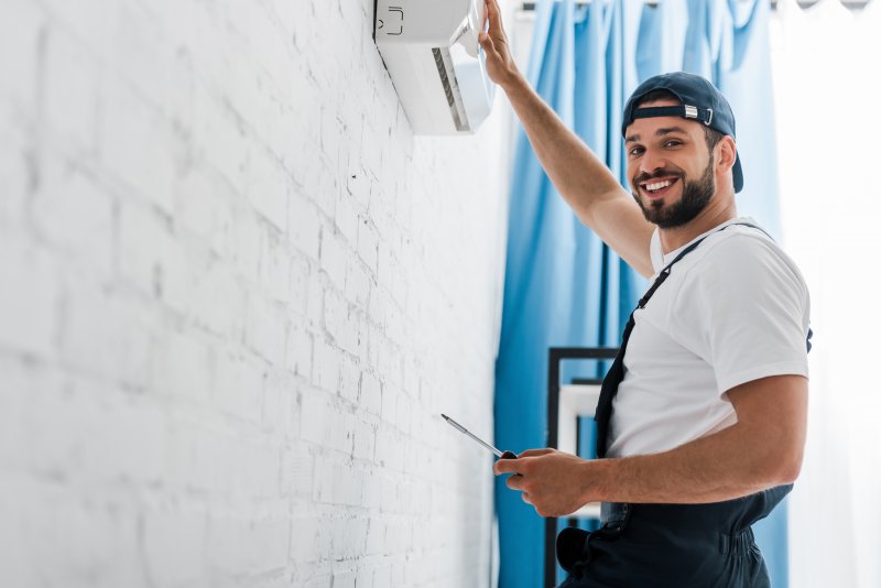 an HVAC technician smiling while working